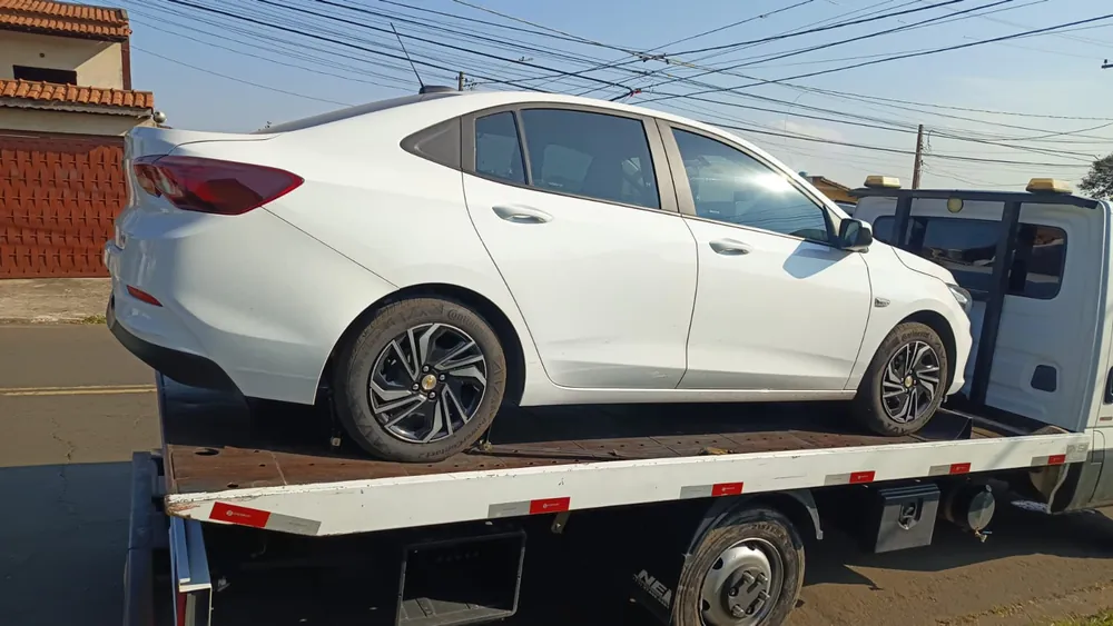 Sedã branco transportado pelo guincho